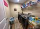Well-lit laundry room featuring modern washer and dryer, storage shelves, and ample space at 118 Cypress Acres Ln, Statesville, NC 28625