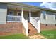 Covered patio area with stairs leading down, featuring a blend of brick and siding at 118 Cypress Acres Ln, Statesville, NC 28625
