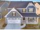 Two-story gray house with white garage door, porch, and landscaping at 1844 Giana Ln, Monroe, NC 28112