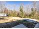 Spacious backyard featuring a basketball court, storage shed, and wooded surroundings at 206 Fox Den Rd, Troy, NC 27371