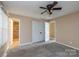 Bright bedroom featuring a ceiling fan, carpeted floor, and closet at 206 Fox Den Rd, Troy, NC 27371