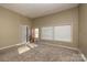 Large living room showcasing natural light, a door to the outside, and neutral carpeting at 206 Fox Den Rd, Troy, NC 27371