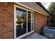 Close-up of a sliding glass door with a brick exterior and concrete patio area at 206 Fox Den Rd, Troy, NC 27371