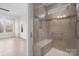 Close-up of a glass-enclosed shower with tiled walls and a built-in seat at 4774 Looking Glass Trl, Denver, NC 28037