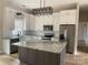 Bright kitchen with white cabinets, stainless steel appliances, a marble countertop island and modern light fixture at 5743 Selkirk Dr, Hickory, NC 28601