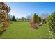 Expansive backyard with a lush lawn, mature trees, and a white garden bench, perfect for relaxation at 5981 Bison Ct, Fort Mill, SC 29707