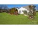 Well-maintained backyard with lush lawn, mature trees, white home exterior, and patio seating at 5981 Bison Ct, Fort Mill, SC 29707