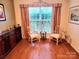 Cozy sitting area with two chairs, a wine rack, and large window with decorative curtains at 5981 Bison Ct, Fort Mill, SC 29707