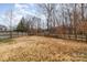 Large, wooded backyard with a wooden fence at 6204 Springbeauty Dr, Charlotte, NC 28227