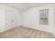 Bright bedroom features neutral carpeting, a window, and a double-door closet at 6204 Springbeauty Dr, Charlotte, NC 28227