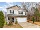 Two-story home showcasing stone accents and a two-car garage with landscaping at 6204 Springbeauty Dr, Charlotte, NC 28227