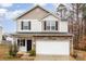 Two-story home showcasing stone accents and a two-car garage against a bright sky backdrop at 6204 Springbeauty Dr, Charlotte, NC 28227