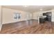 Bright living room features hardwood floors and a sunny window; view into kitchen at 6204 Springbeauty Dr, Charlotte, NC 28227
