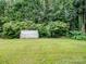 Lush backyard with a small shed, green grass, and mature trees providing privacy at 9903 Southampton Commons Dr, Charlotte, NC 28277