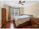 Bright bedroom featuring hardwood floors, a ceiling fan, and natural light from a large window at 9903 Southampton Commons Dr, Charlotte, NC 28277