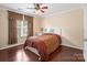 Comfortable bedroom with hardwood floors, neutral walls, and a large window at 9903 Southampton Commons Dr, Charlotte, NC 28277