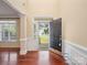 Inviting foyer with hardwood floors, open front door, and views of the landscaped front yard at 9903 Southampton Commons Dr, Charlotte, NC 28277