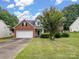 Charming two-story home with brick and siding, a well-manicured lawn, and mature trees at 9903 Southampton Commons Dr, Charlotte, NC 28277