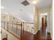 Upstairs hallway with hardwood floors, a wooden railing, and views of the downstairs living area at 9903 Southampton Commons Dr, Charlotte, NC 28277