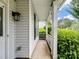 Side view of a covered porch featuring white columns, a lantern, and lush landscaping at 9903 Southampton Commons Dr, Charlotte, NC 28277