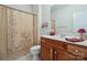 Cozy bathroom features a vanity with wood cabinets, shower with patterned curtain, and a toilet at 1102 High Brook Dr, Waxhaw, NC 28173