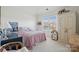 Carpeted bedroom with white walls and natural light, wardrobe, dollhouse, and matching decor at 1102 High Brook Dr, Waxhaw, NC 28173