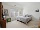 A cozy bedroom with a large window, soft carpet, and a comfortable-looking bed at 1102 High Brook Dr, Waxhaw, NC 28173