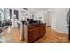 Kitchen island with wooden cabinets, granite countertop, with eat-in dining and hardwood floors at 1102 High Brook Dr, Waxhaw, NC 28173