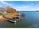 Picturesque aerial view of a waterfront property with a private beach, boat dock, and lush landscaping at 124 Saylors Watch Ln, Mooresville, NC 28117