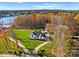 Breathtaking aerial view of a luxury waterfront home surrounded by lush greenery and autumn foliage at 124 Saylors Watch Ln, Mooresville, NC 28117