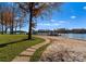 Scenic backyard with a stone path leading to a sandy beach, dock, and boat lift, perfect for waterfront living at 124 Saylors Watch Ln, Mooresville, NC 28117