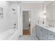 Bright bathroom features a tub with shower and blue vanity with elegant fixtures at 124 Saylors Watch Ln, Mooresville, NC 28117