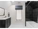 Modern bathroom featuring a double vanity, sleek black shower tiles, and a soaking tub under a bright window at 124 Saylors Watch Ln, Mooresville, NC 28117