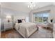 Bedroom featuring a large window with seating, tufted headboard and hardwood floors at 124 Saylors Watch Ln, Mooresville, NC 28117