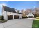 Rear exterior view of a modern home with a three-car garage and detached single-car garage at 124 Saylors Watch Ln, Mooresville, NC 28117