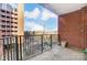 Condo balcony featuring brick wall, black railing, and a view of a construction site at 300 W 5Th St # 339, Charlotte, NC 28202