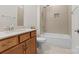 Clean bathroom with shower/tub combo, wood vanity, and tile flooring at 9023 Daring Ct, Charlotte, NC 28215