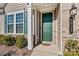 Green front door with sidelights and a house number plaque at 9023 Daring Ct, Charlotte, NC 28215