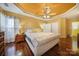 Main bedroom with hardwood floors, beige upholstered bed, and ceiling fan at 9450 Shumacher Nw Ave, Concord, NC 28027