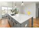 Kitchen island with quartz countertop, black sink, and modern faucet at 104 Isle Of Pines Rd, Mooresville, NC 28117