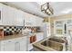 Bright kitchen with white cabinetry, checkered backsplash, and stainless steel sink at 105 Whimbrel Ln, Mooresville, NC 28117