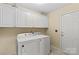 Convenient laundry room featuring a washer, dryer, and ample storage cabinets at 105 Whimbrel Ln, Mooresville, NC 28117