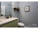 Simple bathroom with green vanity, white countertop, and framed art at 123 Kingfisher Dr, Mooresville, NC 28117