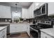 Bright kitchen featuring white cabinets and stainless steel appliances at 123 Kingfisher Dr, Mooresville, NC 28117