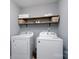 Functional laundry room with washer, dryer, and wooden shelving at 123 Kingfisher Dr, Mooresville, NC 28117