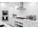 White kitchen with stainless steel appliances and open shelving at 19216 Wildcat Trl, Davidson, NC 28036