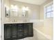 Bathroom with double vanity, bathtub, and dark cabinets at 9182 Bonnie Briar Cir, Charlotte, NC 28277