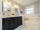 Bright bathroom with double vanity, marble countertop, soaking tub, and natural light from large window at 9182 Bonnie Briar Cir, Charlotte, NC 28277