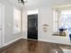 Inviting foyer with dark wood floors, black front door, and bright natural light at 9182 Bonnie Briar Cir, Charlotte, NC 28277