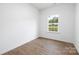 Simple bedroom with hardwood floors and a window offering natural light at 1013 Cathey Rd, Charlotte, NC 28214